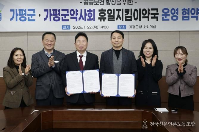 서태원 가평군수(사진 왼쪽에서 세번째)와 안병현 가평군약사회 회장(〃 네번째) 등이 22일 휴일지킴이약국 운영 협약식 후 협약서를 보이며 기념촬영을 하고 있다.