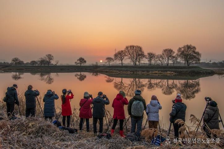 남도풍경연구소 소속 사진작가들이 동섬에서 떠오르는 해를 촬영하고 있는 모습.(사진 제공-나주시)